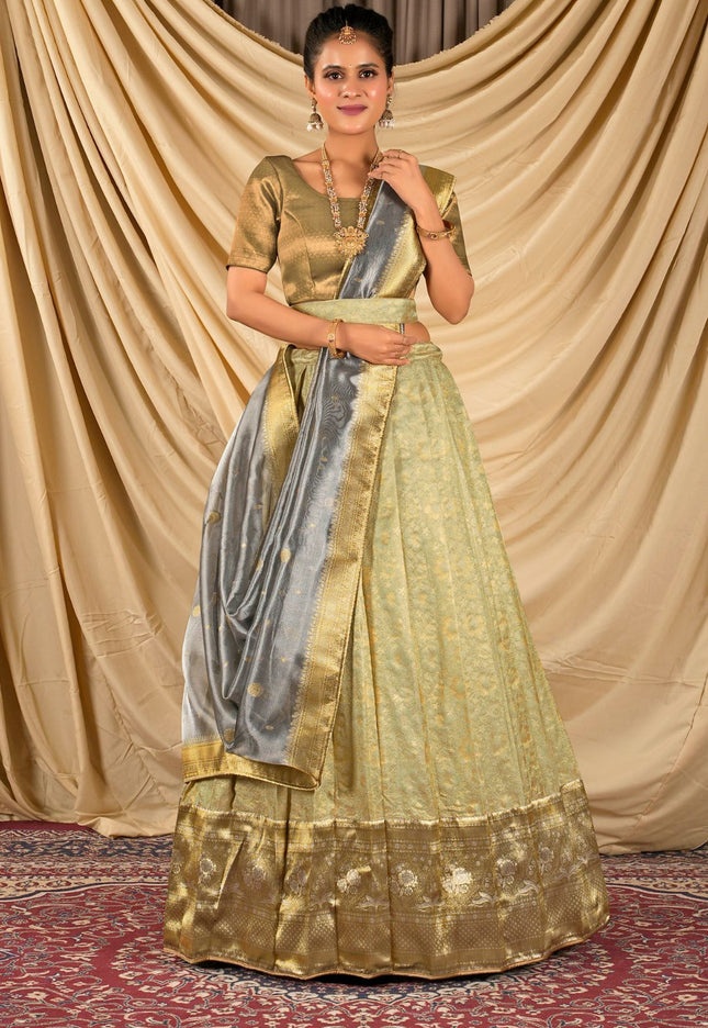 Woman wearing a traditional gold and green lehenga choli with dupatta