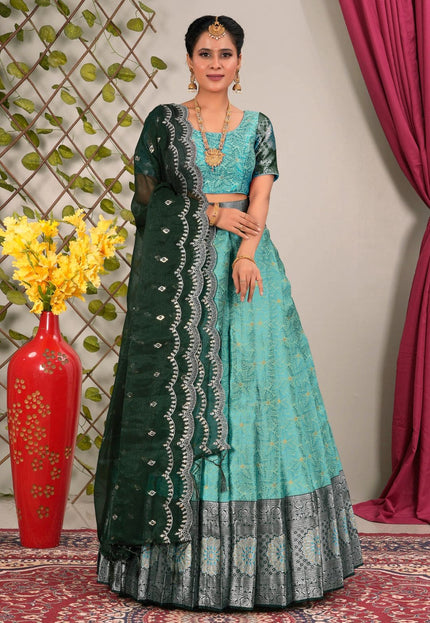 Woman wearing a sky blue and green traditional lehenga choli with dupatta