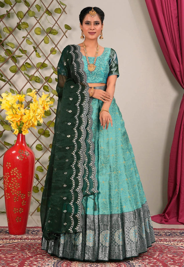 Woman wearing a sky blue and green traditional lehenga choli with dupatta