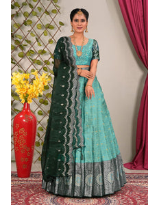 Woman wearing a sky blue and green traditional lehenga choli with dupatta