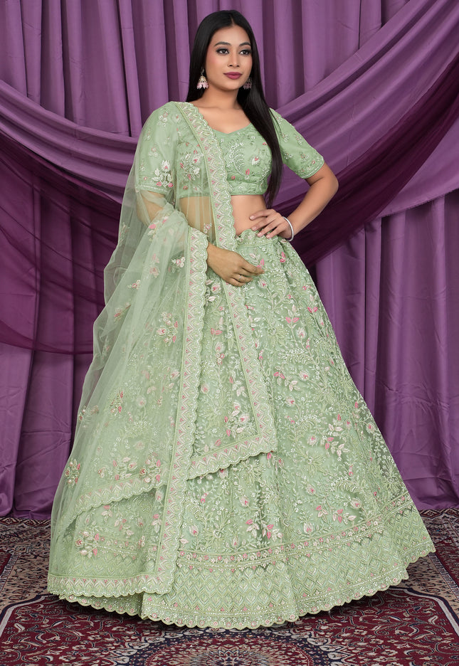 Woman wearing a light green embroidered lehenga choli