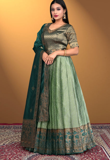 Woman wearing a green traditional outfit with a matching dupatta