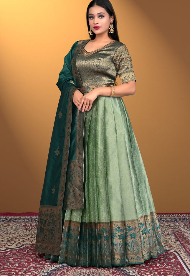Woman wearing a green traditional outfit with a matching dupatta