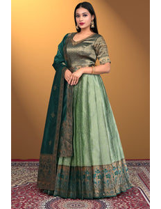 Woman wearing a green traditional outfit with a matching dupatta