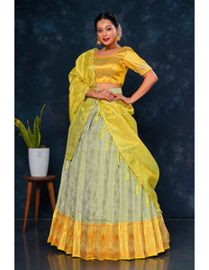 Woman in a yellow and green traditional lehenga choli with dupatta