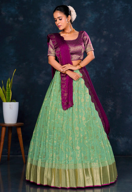 Woman wearing a green and purple traditional lehenga choli with dupatta
