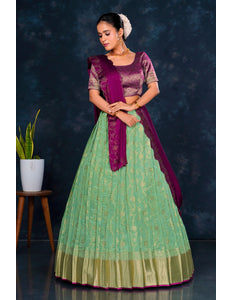 Woman wearing a green and purple traditional lehenga choli with dupatta