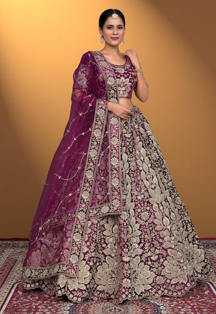Woman wearing a traditional embroidered outfit with a purple dupatta