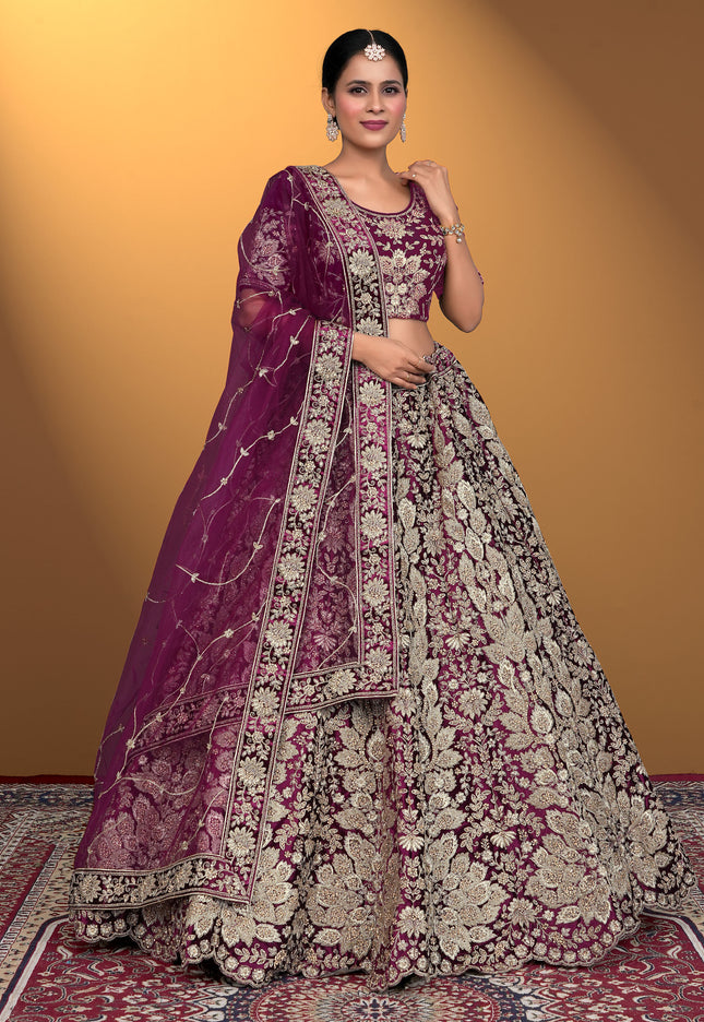 Woman wearing a traditional embroidered outfit with a purple dupatta