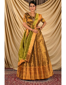 Woman wearing a traditional gold and green lehenga choli