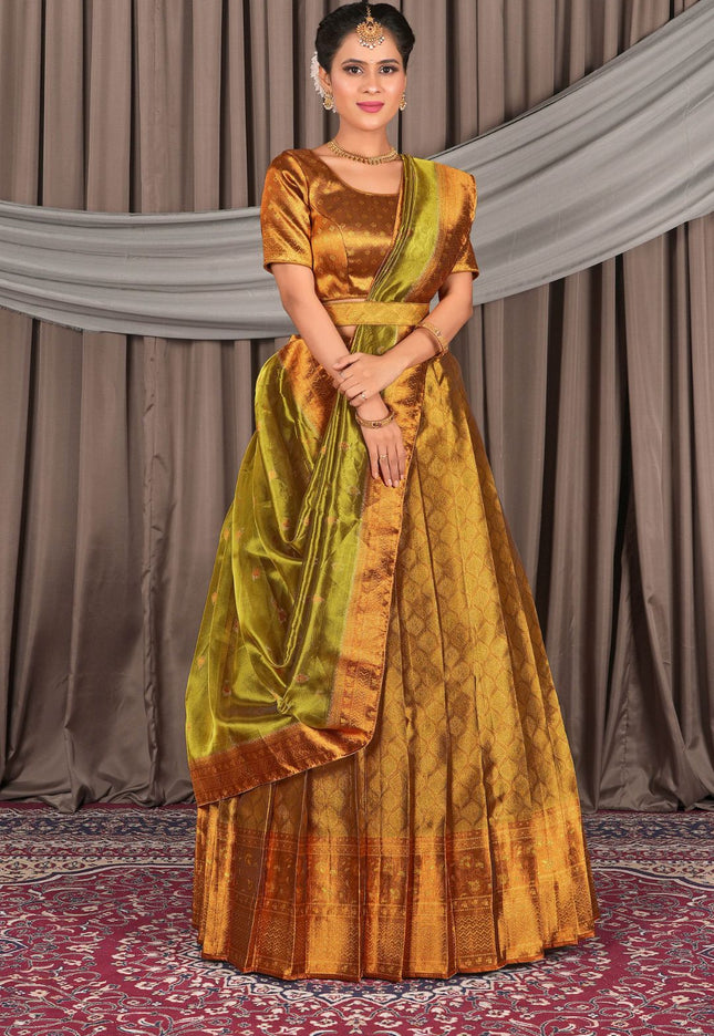 Woman wearing a traditional gold and green lehenga choli with dupatta