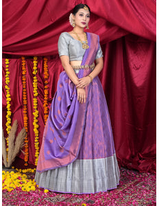 Woman in a traditional outfit with a purple lehenga and silver blouse