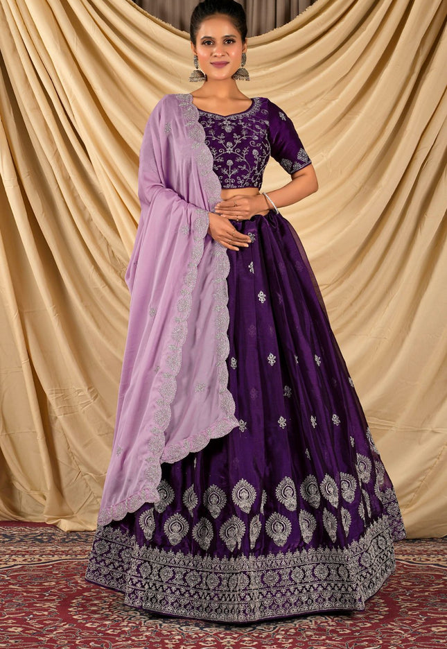Woman wearing a purple traditional outfit with a matching dupatta