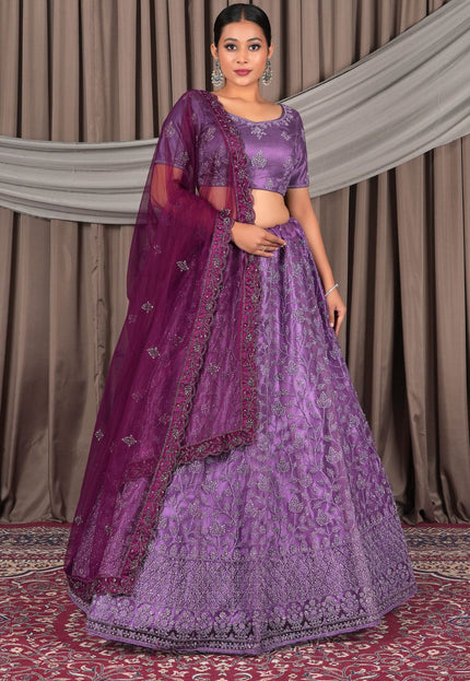 Woman wearing a purple traditional outfit with a matching dupatta