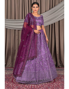 Woman wearing a purple traditional outfit with a matching dupatta