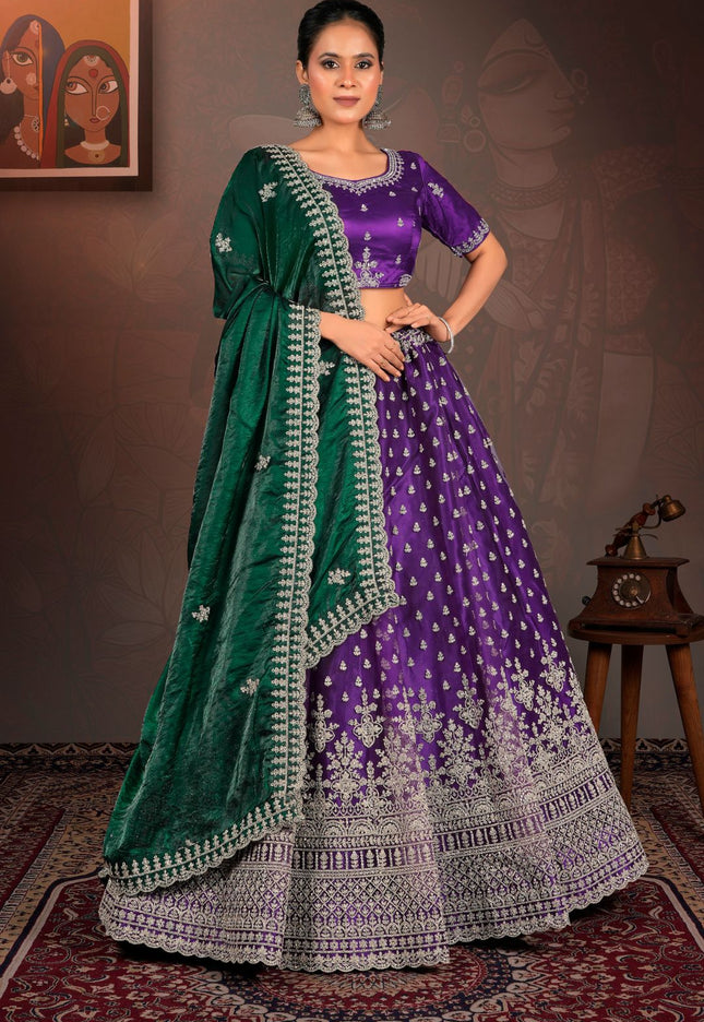 Woman wearing a traditional purple and green lehenga with intricate patterns.