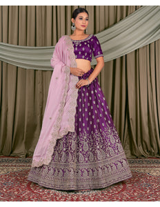 Woman wearing a traditional purple and pink embroidered outfit