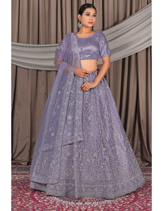 Woman wearing a traditional lavender outfit with a matching dupatta