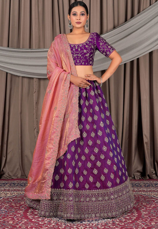 Woman wearing a purple traditional outfit with a pink dupatta