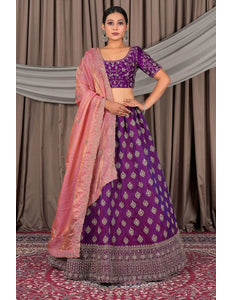 Woman wearing a purple traditional outfit with a pink dupatta