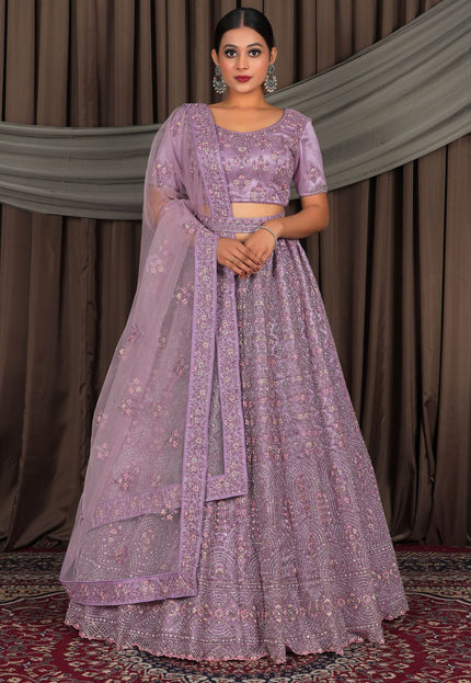 Woman wearing a purple traditional outfit with a matching dupatta