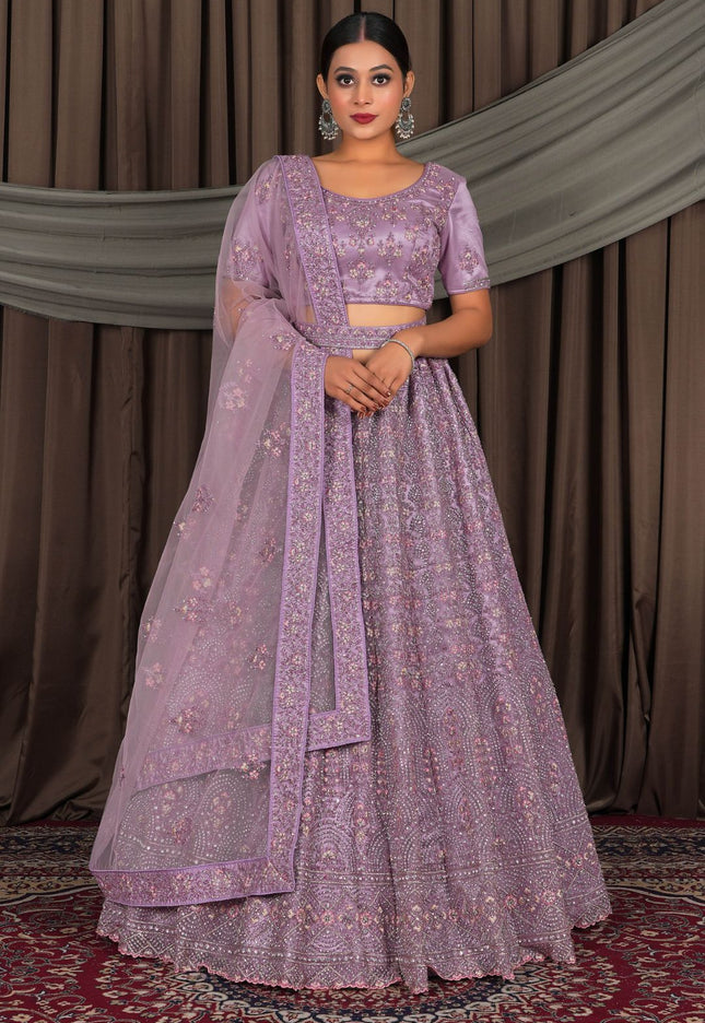 Woman wearing a purple traditional outfit with a matching dupatta