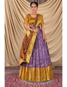 Woman wearing a traditional outfit with a gold blouse and purple skirt