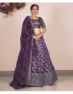 Woman wearing a purple traditional outfit with a matching dupatta