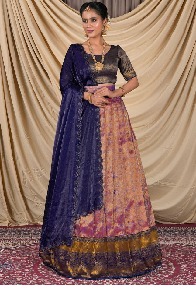 Woman wearing a traditional outfit with a blue dupatta and patterned skirt