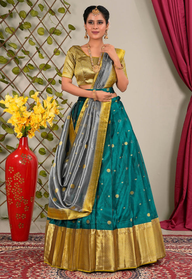 Woman wearing a traditional outfit with a green and gold lehenga choli with dupatta