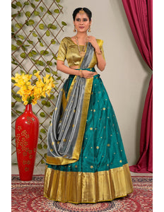 Woman wearing a traditional outfit with a green and gold lehenga choli with dupatta