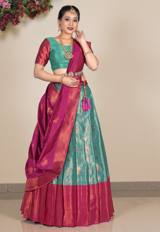 Woman wearing a traditional saree with a green lehenga and blouse and pink dupatta
