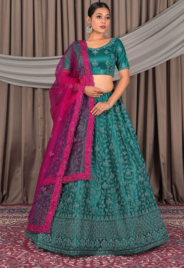 Woman in a traditional green and pink embroidered lehenga choli with dupatta