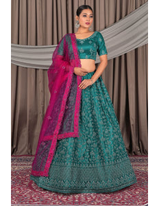 Woman in a traditional green and pink embroidered lehenga choli with dupatta