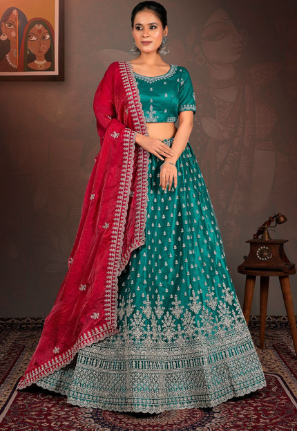 Woman in a teal and red traditional lehenga choli with red dupatta
