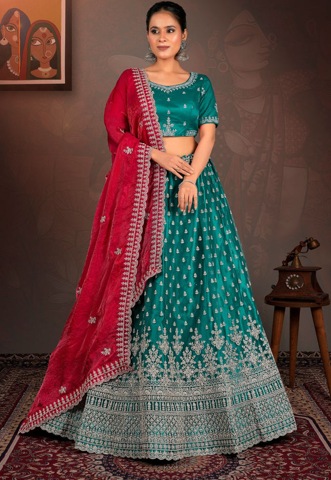 Woman in a teal and red traditional lehenga choli with red dupatta