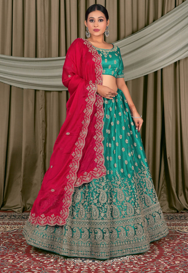 Woman in traditional green and pink embroidered outfit standing