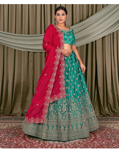 Woman in traditional green and pink embroidered outfit standing