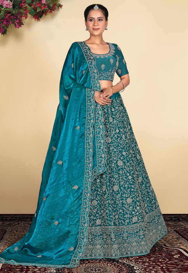 Woman wearing a teal embroidered traditional outfit