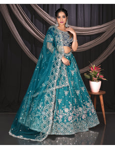 Woman in a teal embroidered traditional outfit
