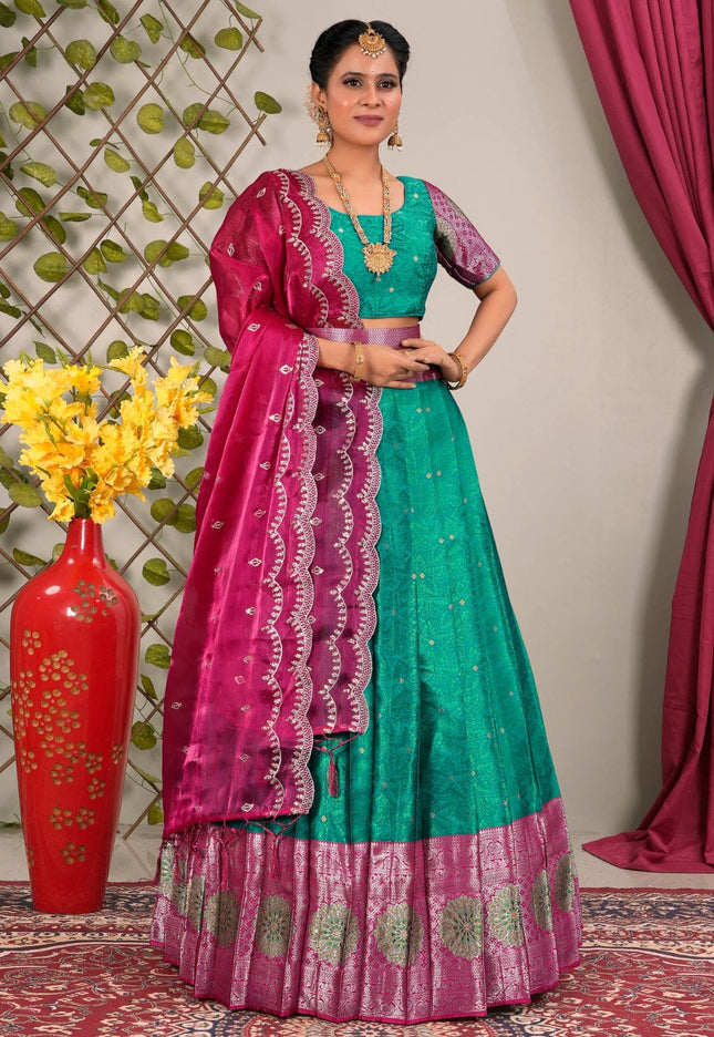 Woman wearing a green and pink traditional outfit with a matching dupatta