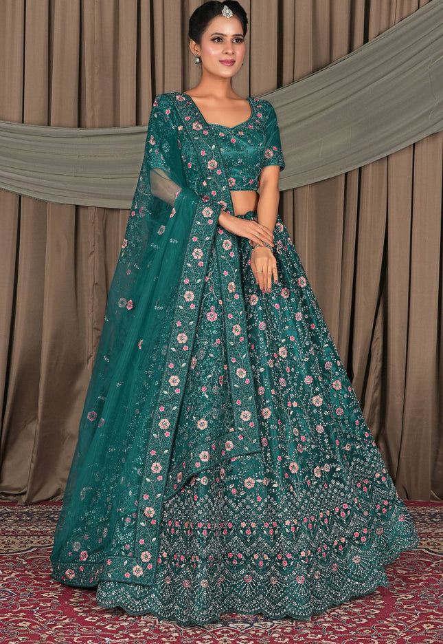 Woman wearing a teal embroidered traditional outfit with a floral pattern
