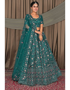 Woman wearing a teal embroidered traditional outfit with a floral pattern