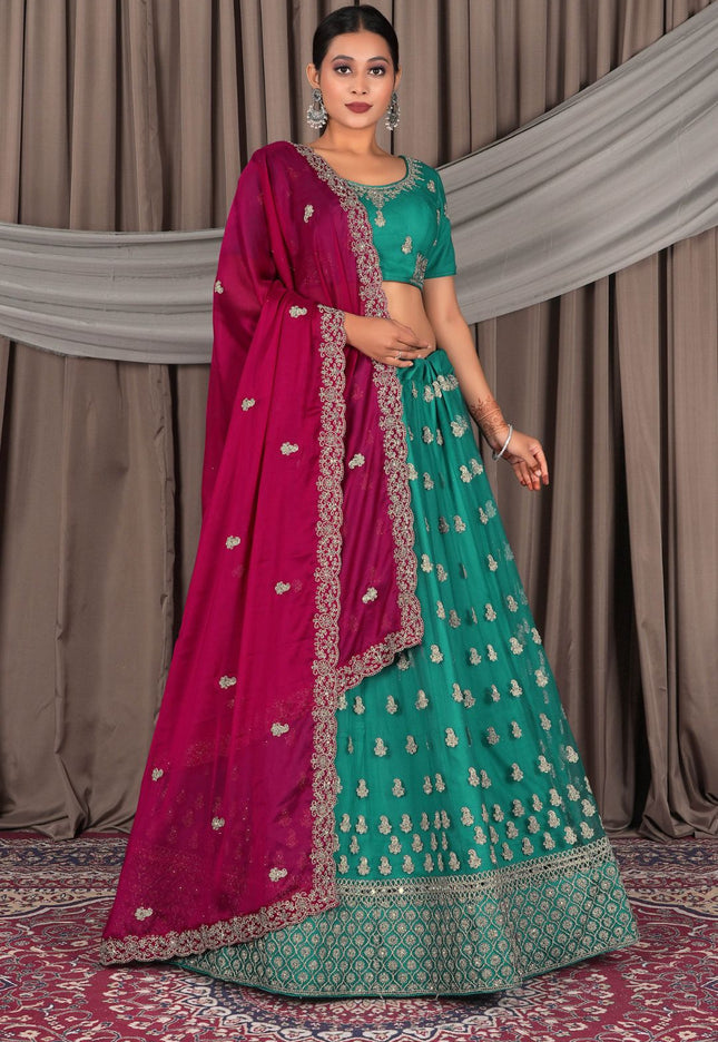 Woman wearing a traditional green and pink saree with a matching blouse