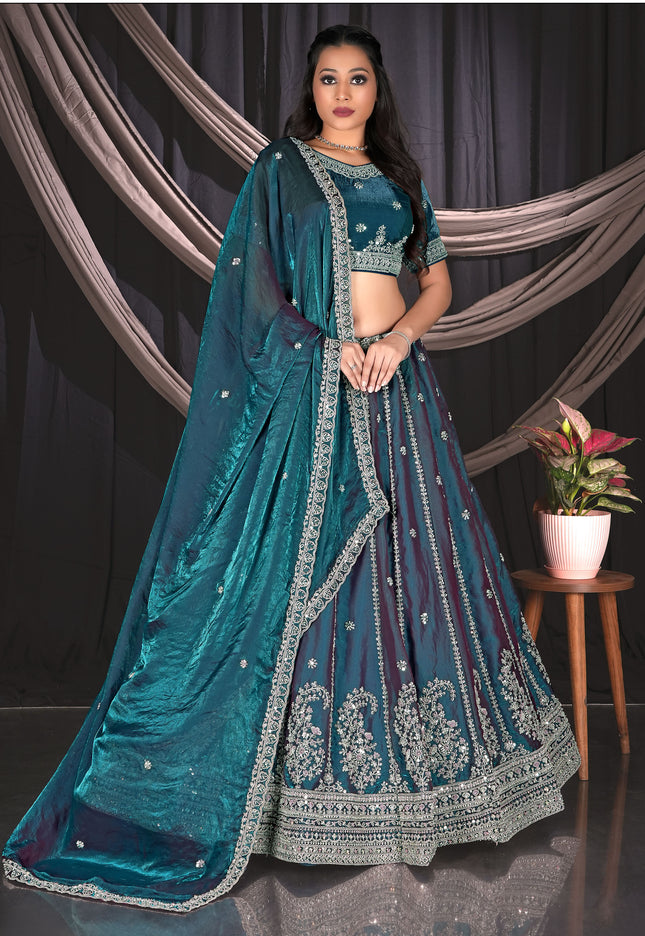 Woman wearing a teal embroidered traditional lehenga choli