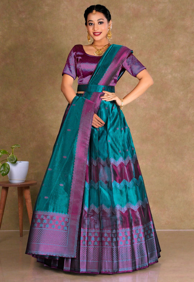 Woman wearing a traditional teal and purple lehenga with a matching blouse
