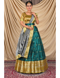 Woman wearing a traditional green and gold lehenga choli with dupatta