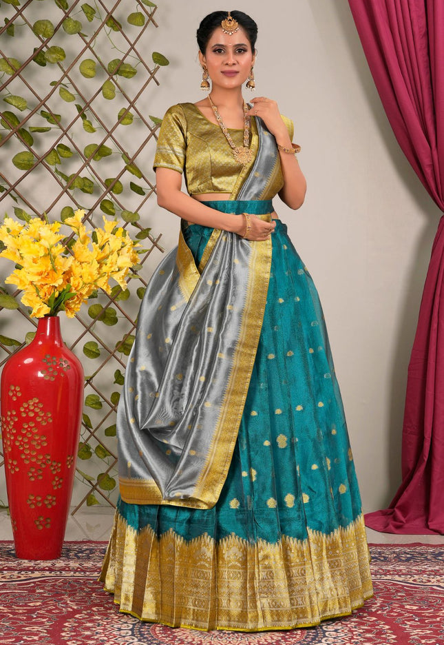 Woman in a traditional outfit with a teal and gold lehenga choli with dupatta