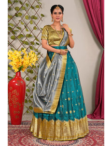 Woman in a traditional outfit with a teal and gold lehenga choli with dupatta