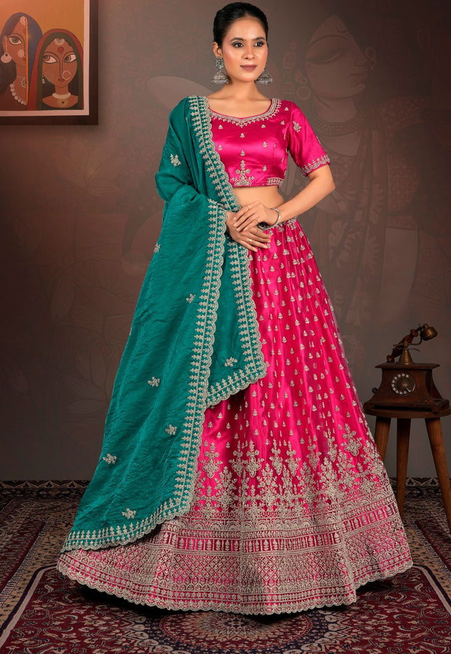 Woman wearing a pink and green traditional lehenga choli with dupatta